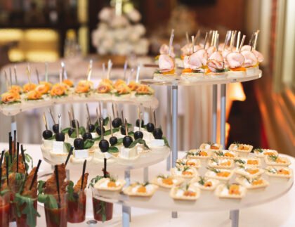 Catering table buffet dinner, beautifully decorated banquet with variety of different food snacks and appetizers on corporate birthday party event or wedding reception, canape, delicatessen setting